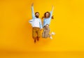 Couple of emotional people man and woman jumping on yellow background Royalty Free Stock Photo