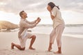 Couple, engagement proposal and surprise at beach with smile, happiness or love on vacation in sunset. Man, woman and Royalty Free Stock Photo