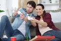 couple engrossed in computer game surrounded by take-away wrappers