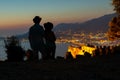 Couple enjoy the view from the fortress. Stone walls. Lighting and night atmosphere. Touristic point. View of the city lights.