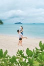 A couple enjoying a beach vacation at a tropical resort with a beautifully landscaped coastal pool at sunset. honeymoon