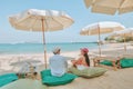 A couple enjoying a beach vacation at a tropical resort with a beautifully landscaped coastal pool at sunset. honeymoon