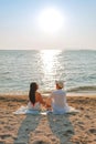 A couple enjoying a beach vacation at a tropical resort with a beautifully landscaped coastal pool at sunset. honeymoon