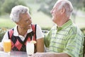 Couple Enjoying A Beverage By A Golf Course Royalty Free Stock Photo