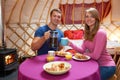 Couple Enjoying Breakfast Whilst Camping In Traditional Yurt Royalty Free Stock Photo