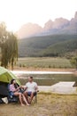 Couple Enjoying Camping Vacation By Lake Making A Toast