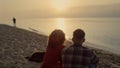 Couple enjoying ocean view at sunset. Lovers spending summer vacation on beach Royalty Free Stock Photo