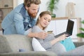 couple enjoying online shopping sitting on sofa at home Royalty Free Stock Photo