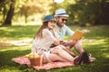 Couple enjoying picnic time outdoor reading book