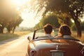 A couple enjoying a serene drive in a classic convertible car on a tree-lined road at sunset