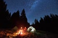 Couple enjoying starry night sky near campfire. Royalty Free Stock Photo