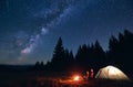 Couple enjoying starry night sky near campfire. Royalty Free Stock Photo