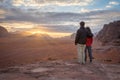 A couple enjoying sunrise over landscape and mountains in Wadi Rum in Jordan Royalty Free Stock Photo