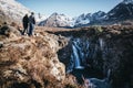 Couple enjoys the view on the beautiful Fairy Pools on the Isle of Skye, Scotland