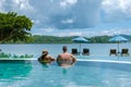 couple European man and Asian woman in infinity pool in Thailand looking out over the ocean, luxury vacation in Thailand Royalty Free Stock Photo