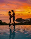 couple in infinity pool in Thailand looking out over the ocean, luxury vacation in Thailand Royalty Free Stock Photo