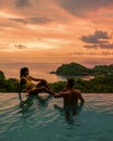 couple in infinity pool in Thailand looking out over the ocean, luxury vacation in Thailand Royalty Free Stock Photo