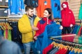 Couple examining track jackets in sports clothes store Royalty Free Stock Photo