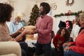 Couple Exchanging Gifts As Multi Generation Family Celebrate Christmas At Home Together Royalty Free Stock Photo