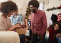 Couple Exchanging Gifts As Multi Generation Family Celebrate Christmas At Home Together Royalty Free Stock Photo