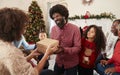 Couple Exchanging Gifts As Multi Generation Family Celebrate Christmas At Home Together Royalty Free Stock Photo