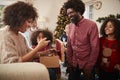 Couple Exchanging Gifts As Multi Generation Family Celebrate Christmas At Home Together Royalty Free Stock Photo