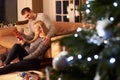 Couple Exchanging Gifts By Christmas Tree