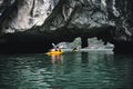 Couple exploring cave on kayak and taking photograps in the boat. Ha Long Bay, Vietnam, Cat Ba Island Royalty Free Stock Photo