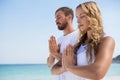 Couple with eyes closed exercising at beach Royalty Free Stock Photo