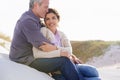 Couple, face and smile outdoor with hug for romance, love and relationship on beach with relaxing. Mature, man and woman Royalty Free Stock Photo