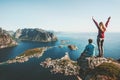 Couple family traveling together on cliff edge in Norway