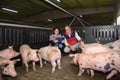 Couple of farmers with a digital tablet on a pig farm