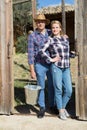 Couple of farmers standing near wooden fence