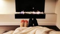 Couple Feet in Socks by Fireplace.