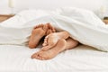 Couple feet under sheets on the bed at home Royalty Free Stock Photo