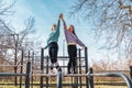 couple of female athletes having fun while climbing on sport metal structure outdoors Royalty Free Stock Photo