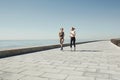 Couple female running exercising jogging happy on waterfront