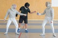couple fencing practice with referee