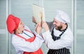 Couple fight for book recipes. Improve cooking skill. Book recipes. Helpful culinary book. Woman chef and man cooking