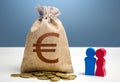 Couple figurines and euro money bag. Social policy to encourage family creation. Segmentation. Marketing and targeting.