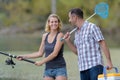 Couple fishing or angling standing on river shore in grass Royalty Free Stock Photo