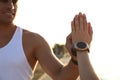 Couple with fitness trackers giving each other high fives after training outdoors, closeup