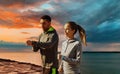 Couple with fitness trackers running over sea