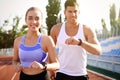 Couple with fitness trackers running at stadium