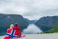 Couple with the flag of Norway looks at the fjord Royalty Free Stock Photo