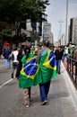 Couple with flag on their back walking through the Demonstration