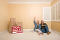 Couple on Floor Near Boxes, Sold Real Estate Signs Royalty Free Stock Photo