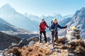 Couple following Everest Base Camp trekking route near Dughla 4620m. Backpackers carrying Backpacks and using trekking poles and Royalty Free Stock Photo
