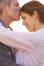 Couple, forehead kiss and hug with love, respect or happiness on holiday in retirement. Mature, man and woman embrace