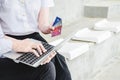 Couple of friend young man and woman student in school uniform Thailand style sitting at university holding discount credit card